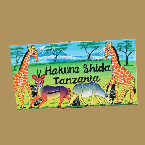 Hand-painted artwork from Tanzania featuring giraffes, an antelope, and a zebra with the phrase 'Hakuna Shida Tanzania' in a lush, green landscape.